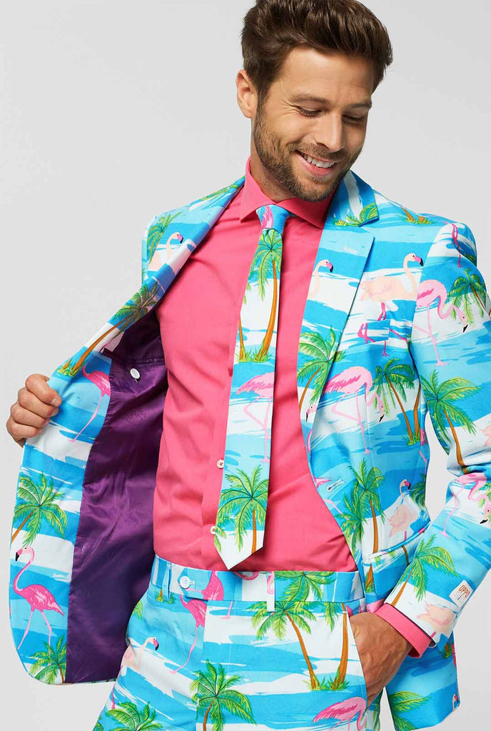 Blauw en wit pak met tropische flamingo print flaminguy gedragen door de mens in de jas die het vasthoudt