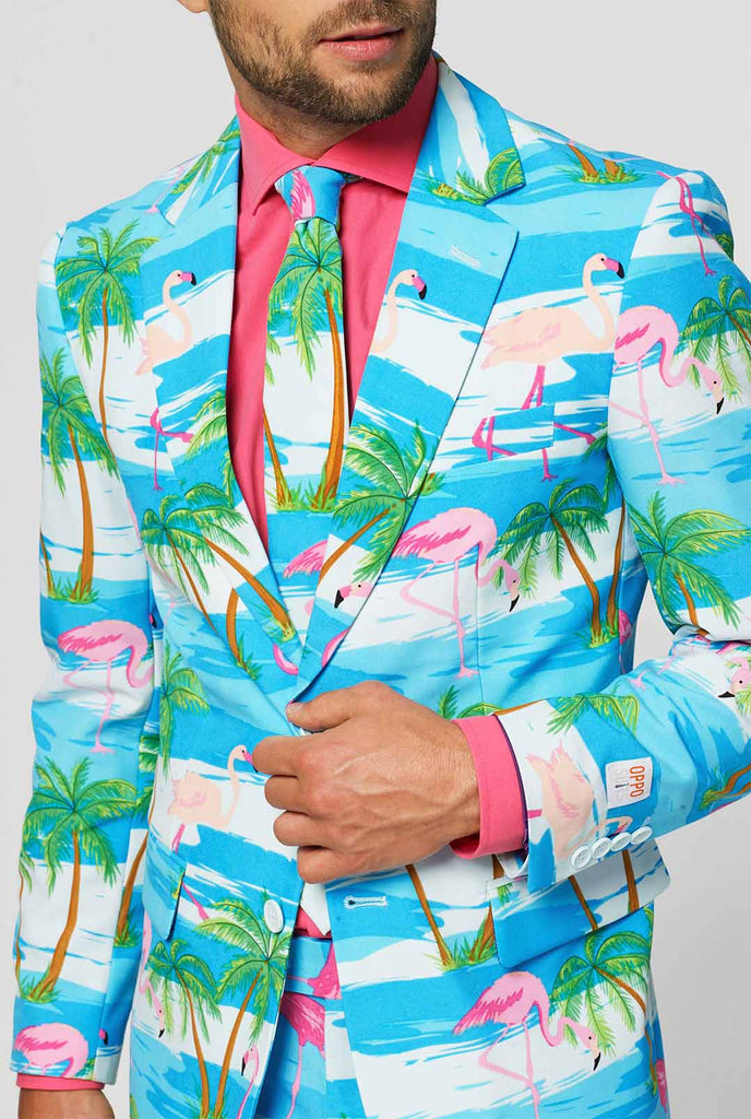 Blauw en wit pak met tropische flamingo print flaminguy gedragen door man in dichte jas