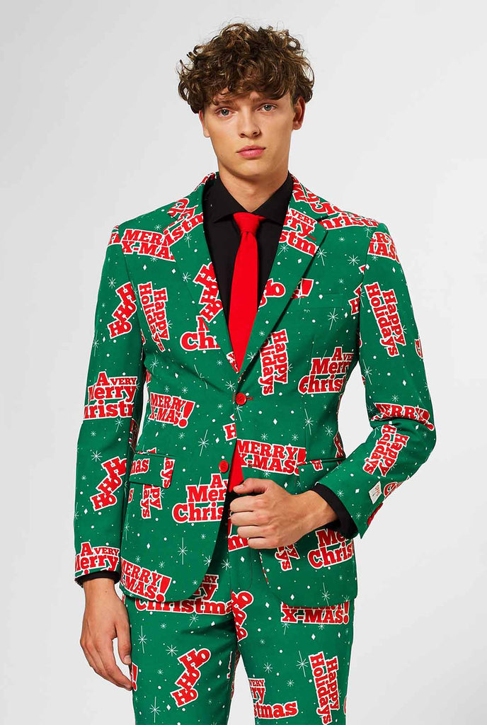 Man draagt ​​groen kerstpak met rode kerstfrases