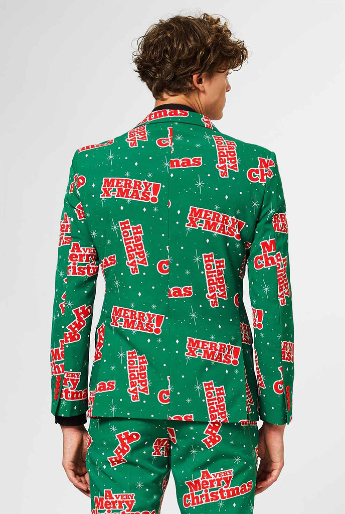 Man draagt ​​groen kerstpak met rode kerstfrases, bekijk vanaf de achterkant