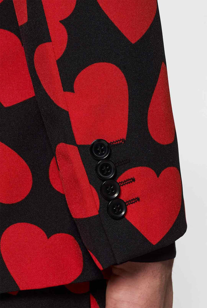 Man draagt ​​een zwart pak met rode harten print, mouw close -up