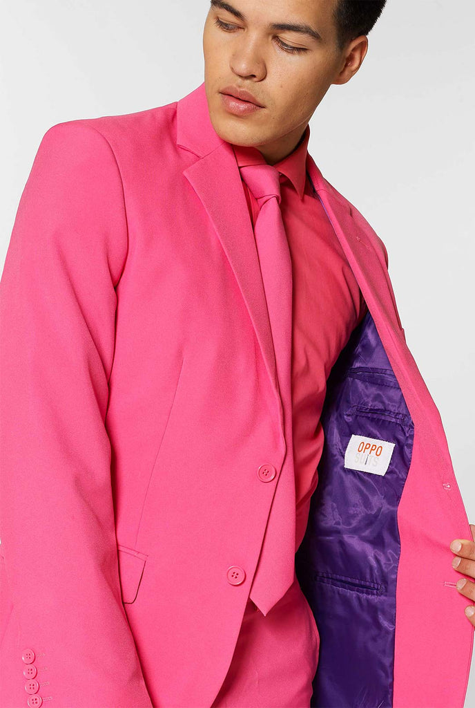 Man draagt ​​roze herenpak met roze overhemd