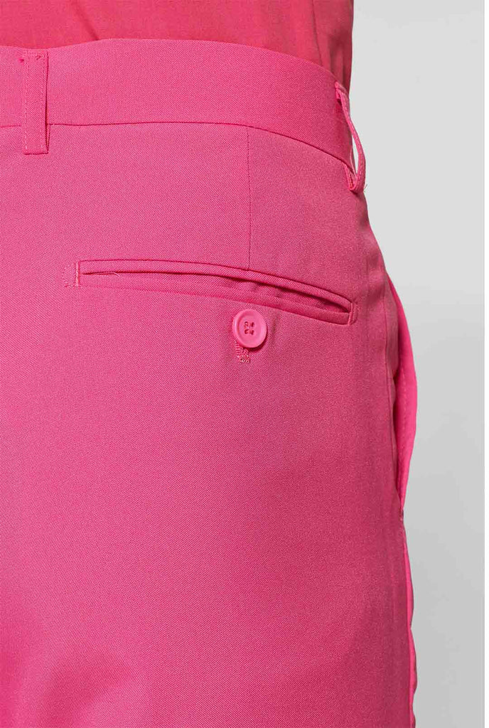Man draagt ​​roze herenpak met roze overhemd, broek van dichtbij