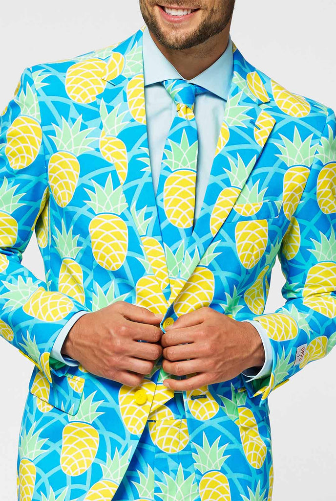 Ananaspak met felle kleuren door man close -up jas