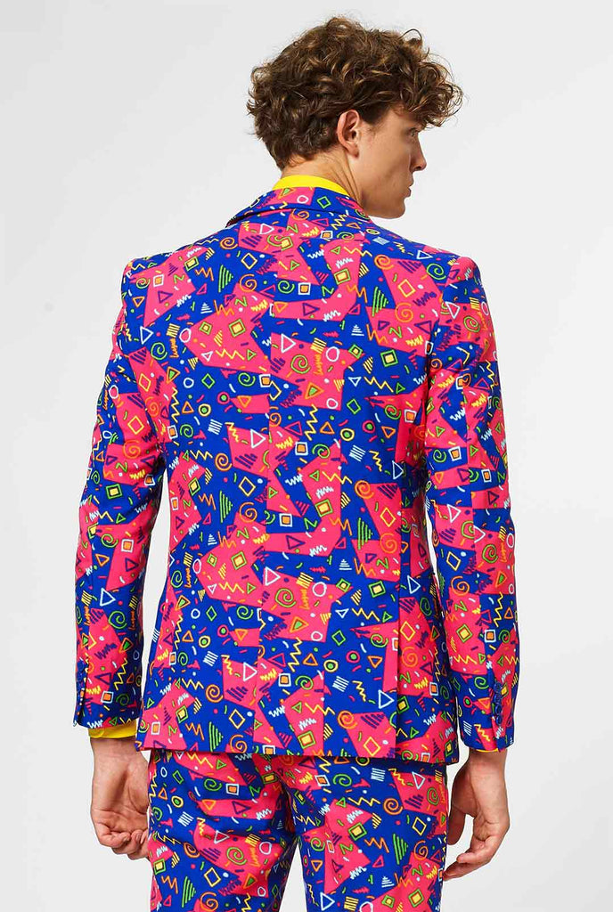 Funky roze en blauw pak met abstracte pictogrammen gedragen door de man die terug worden getoond
