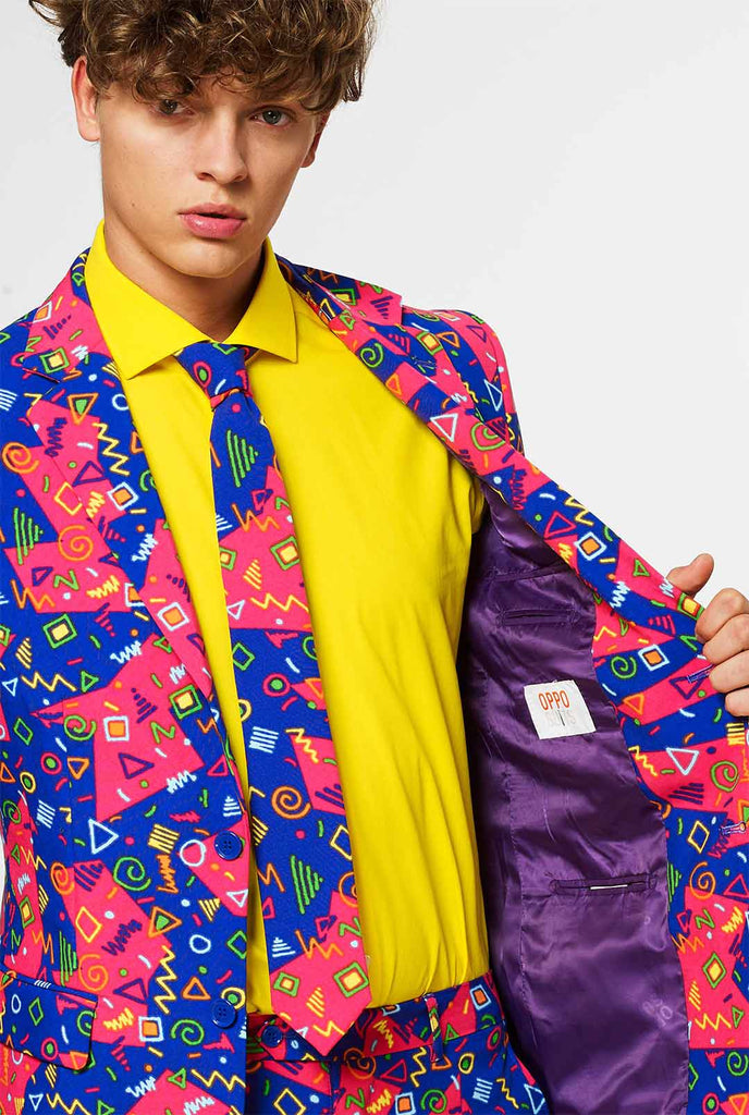 Funky roze en blauw pak met abstracte pictogrammen gedragen door de mens met een jas