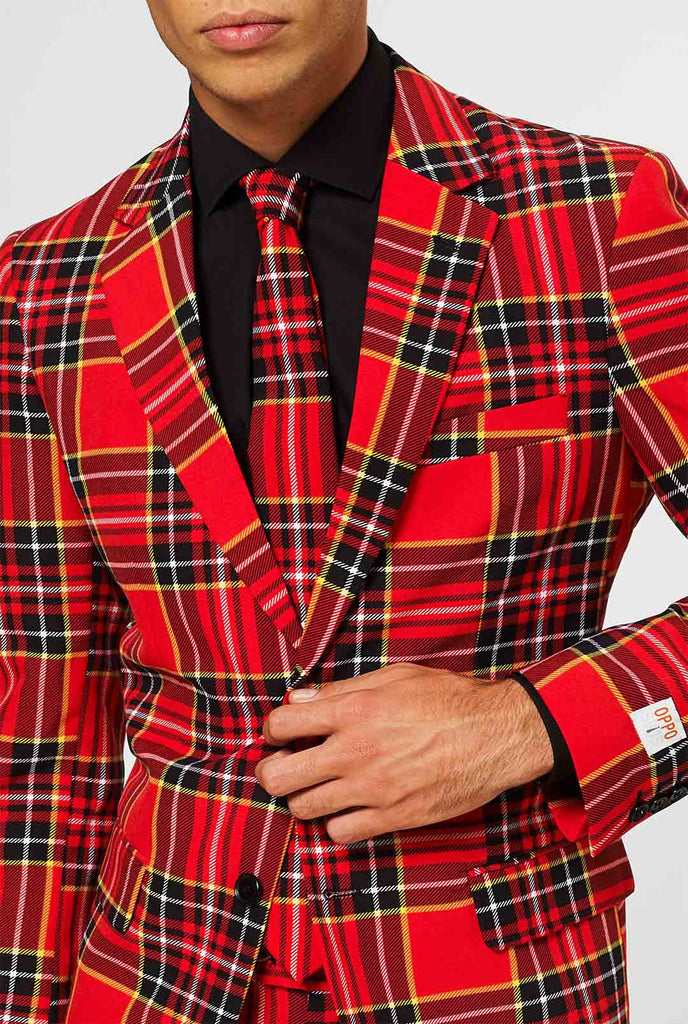 Man draagt ​​een rood kersttartan herenpak, van dichtbij