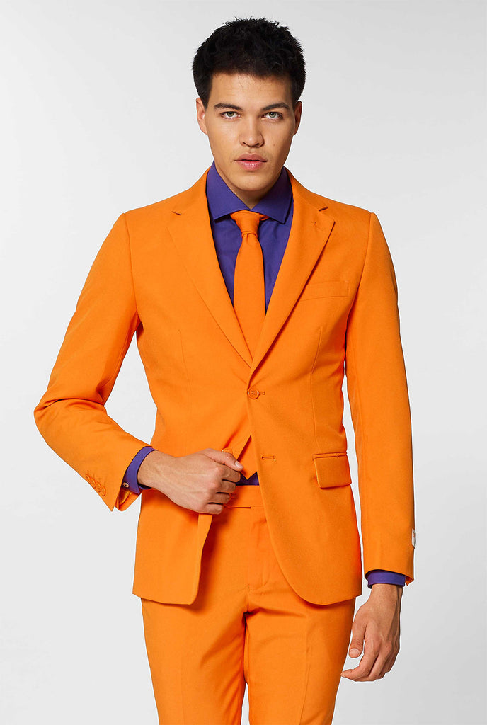 Man draagt ​​oranje herenpak met paars overhemd