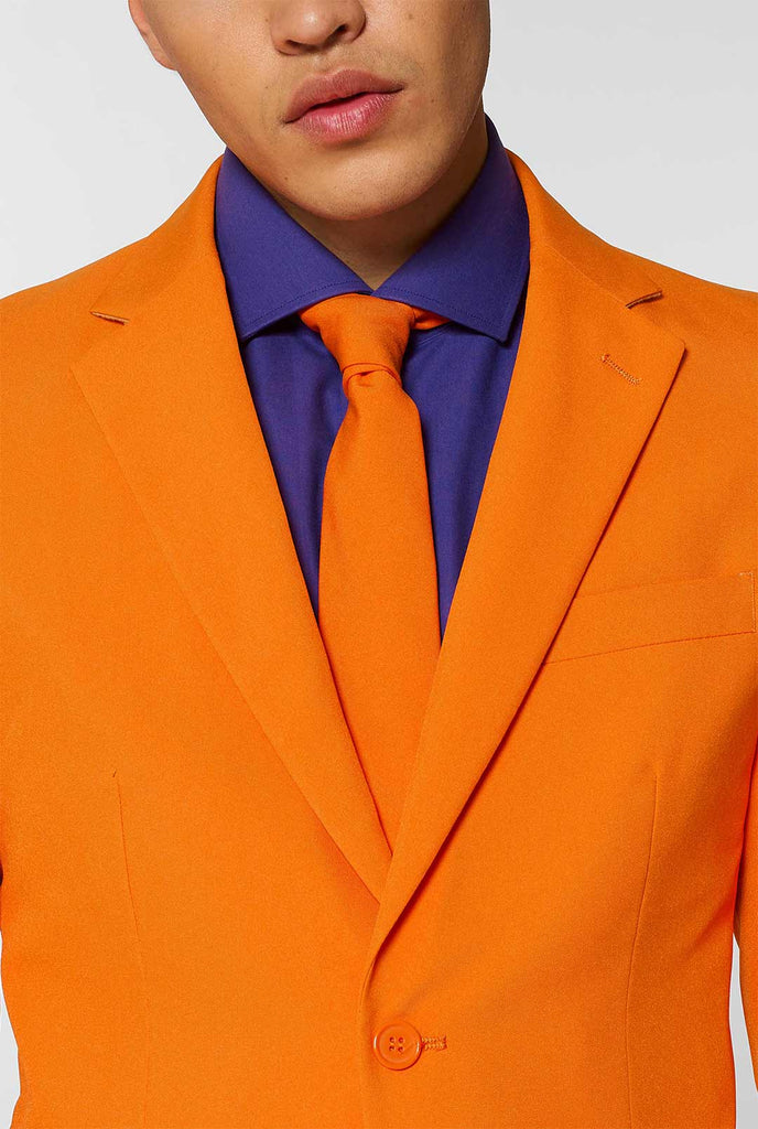 Man draagt ​​oranje herenpak met paars overhemd, van dichtbij