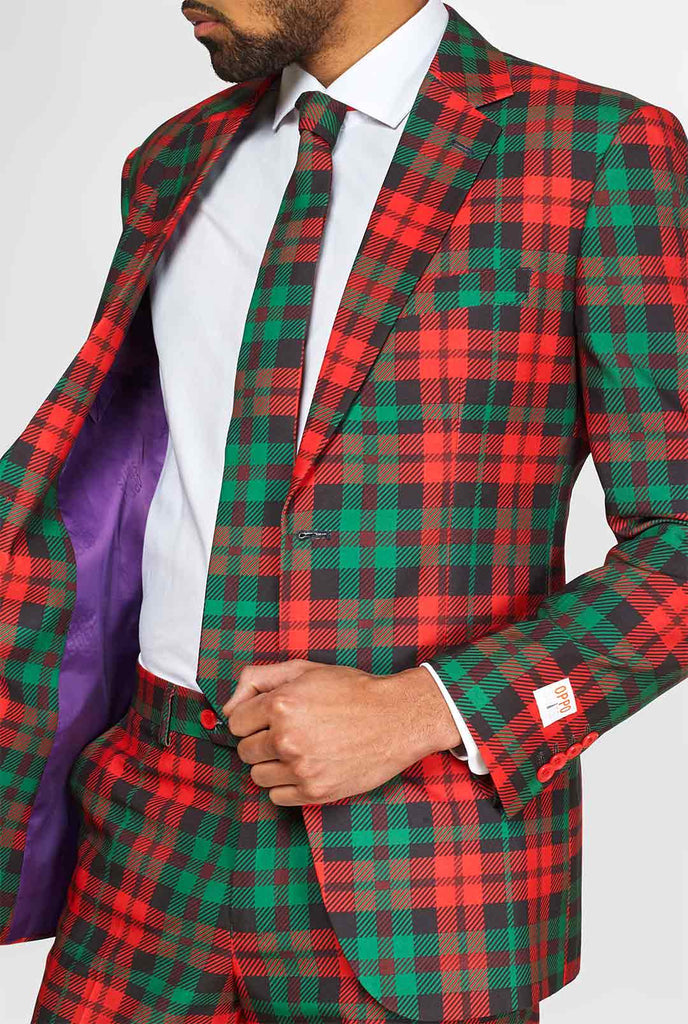 Groen en rood tartan pak gedragen door de mens met een jas