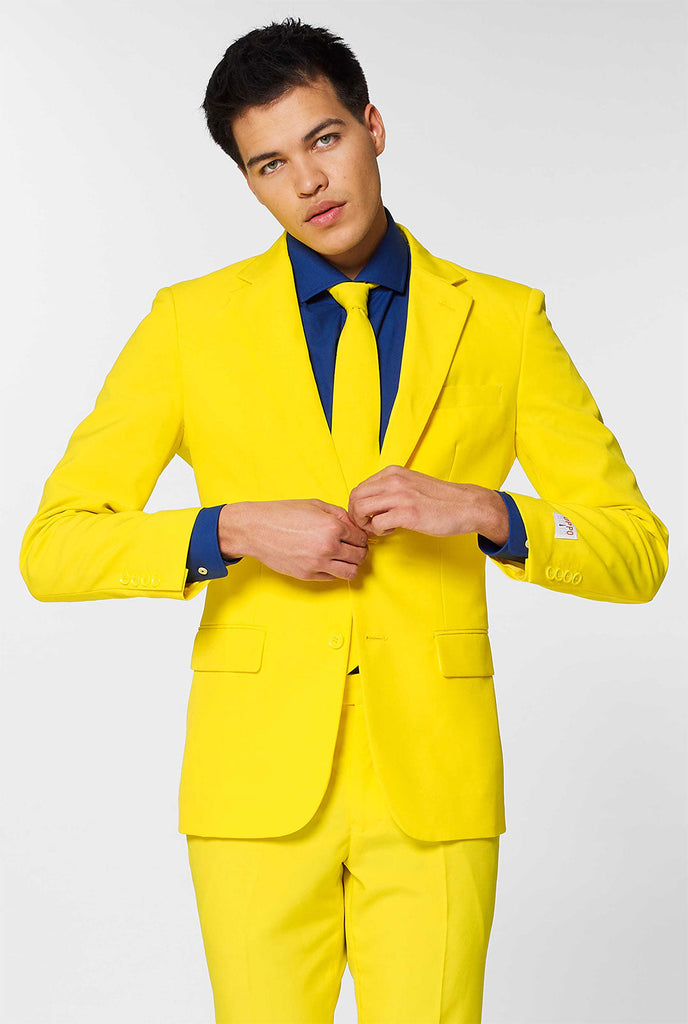 Man draagt ​​een geel herenpak en donkerblauw overhemd