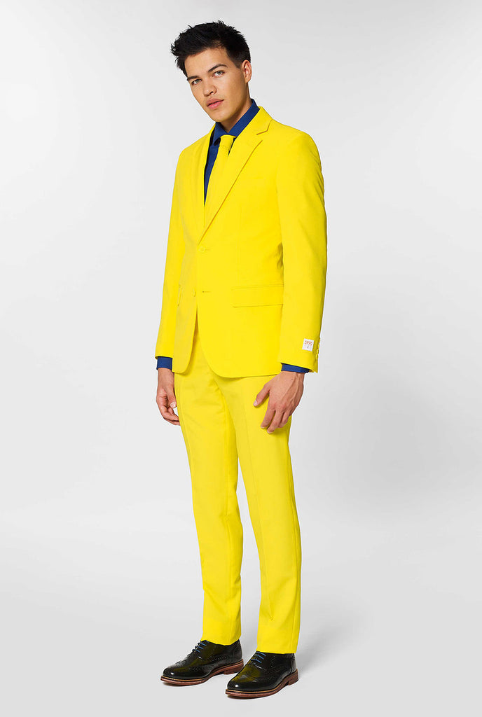 Man draagt ​​een geel herenpak en donkerblauw overhemd