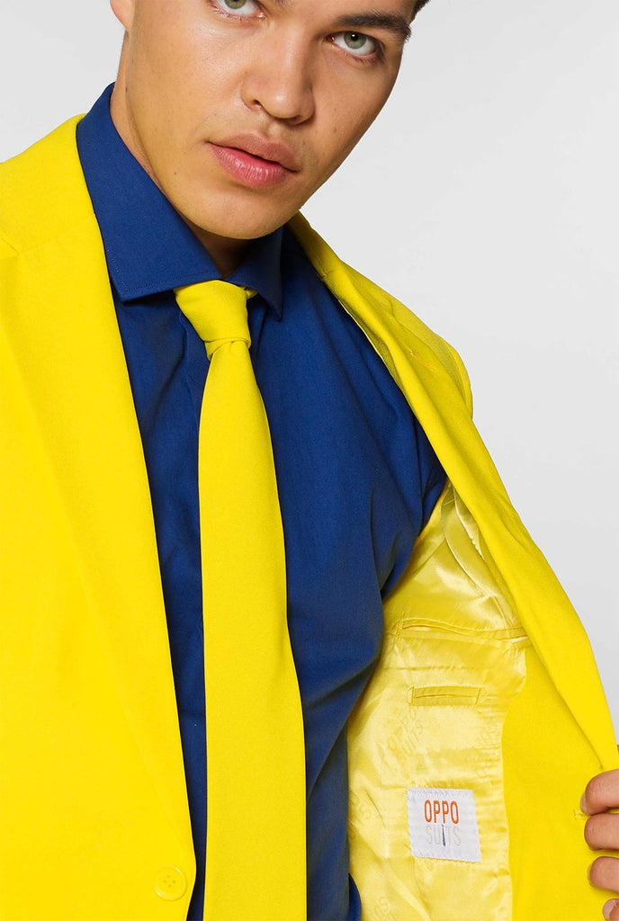 Man draagt ​​geel herenpak en donkerblauw overhemd, dichtbij