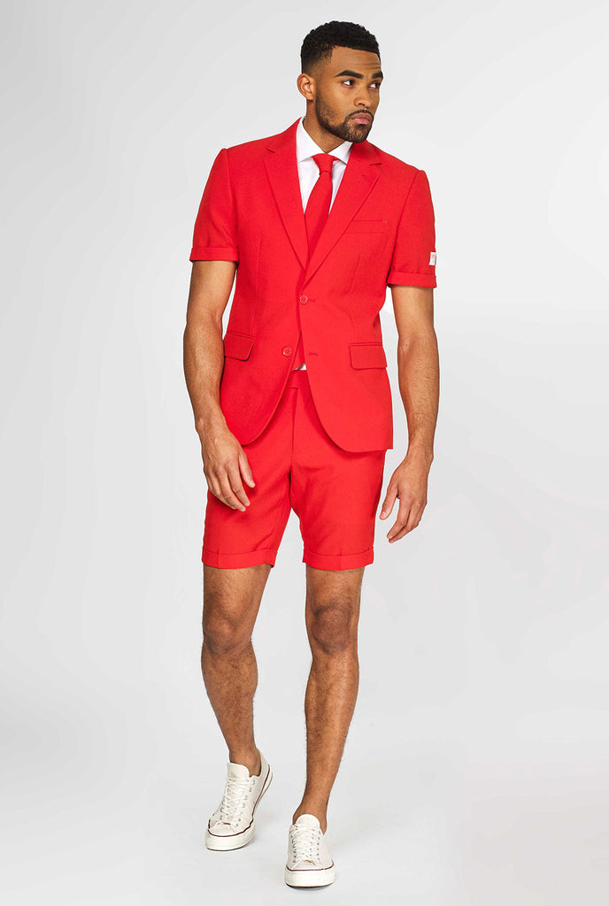 Man draagt ​​een rood zomerpak, bestaande uit shorts, jas en stropdas