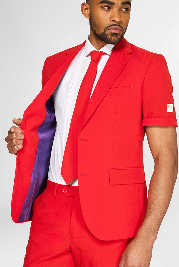 Man draagt ​​een rood zomerpak, bestaande uit shorts, jas en stropdas