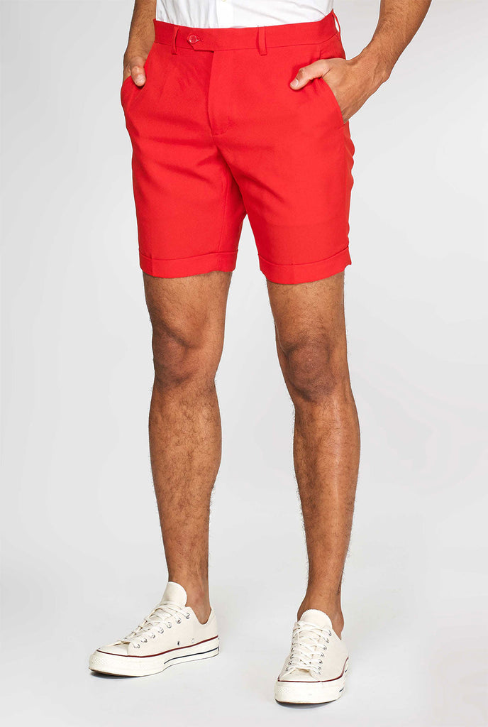 Man draagt ​​een rood zomerpak, bestaande uit shorts, jas en stropdas, close -up van broek