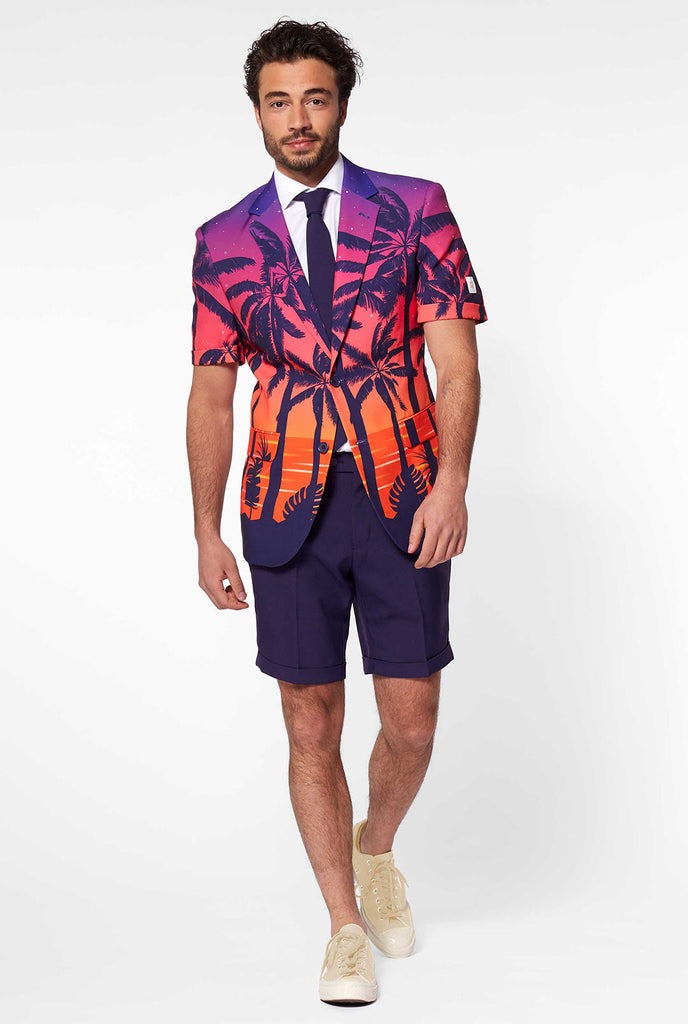 Man draagt ​​zomerpak met palmen en zonsondergangprint