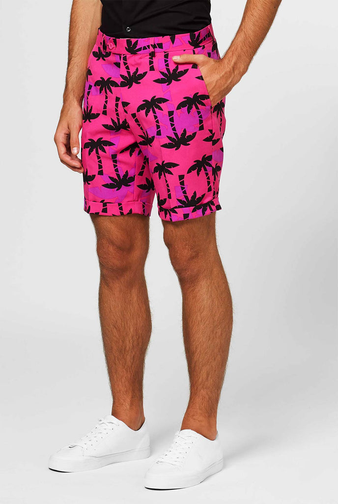Man met roze zomerpak met palmprint, close -up van broek