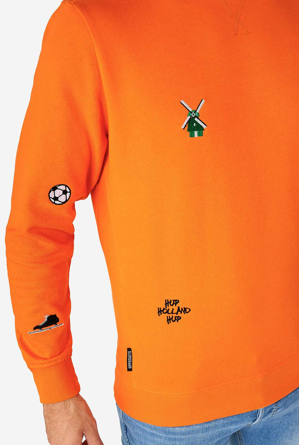 Man draagt ​​een oranje trui met Nederlandse iconen, close -up