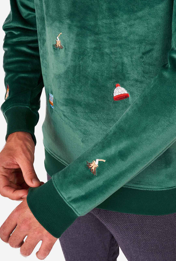 Man draagt ​​fluwelen groene kersttrui met kerstpictogrammen, close -up