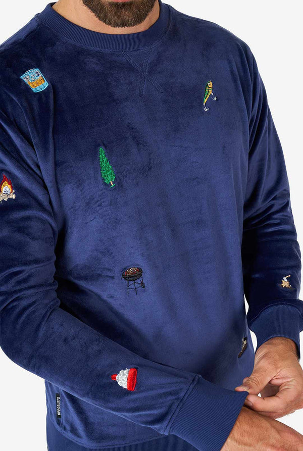 Man draagt ​​fluwelen blauwe kersttrui met kerstpictogrammen, close -up