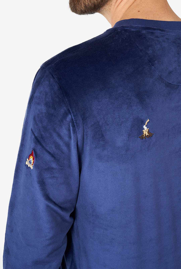 Man draagt ​​fluwelen blauwe kersttrui met kerstpictogrammen, close -up