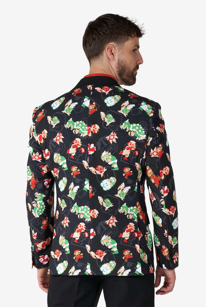 Man draagt ​​zwarte blazer met retro super mario -personages afdrukken, bekijk vanaf de achterkant