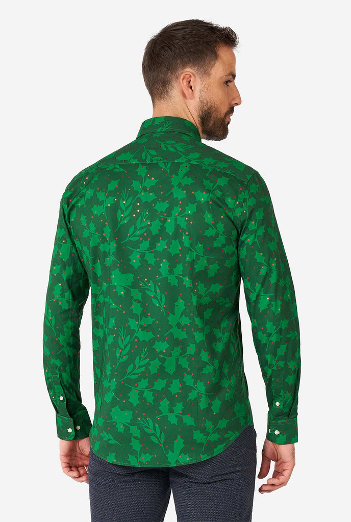 Man draagt ​​groen kerst over shirt met hulst en maretak print, bekijk vanaf de achterkant