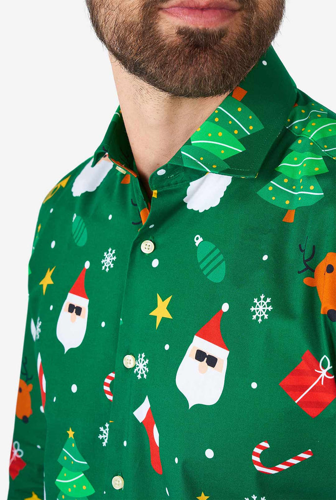 Man draagt ​​groene kerst overhirt met kerstpictogrammen, close -up