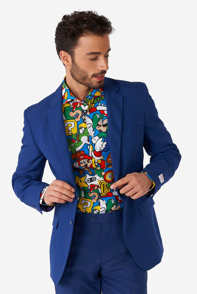 Man draagt ​​een overhemd met Super Mario -pictogrammen afdrukken en blauwe herenpak