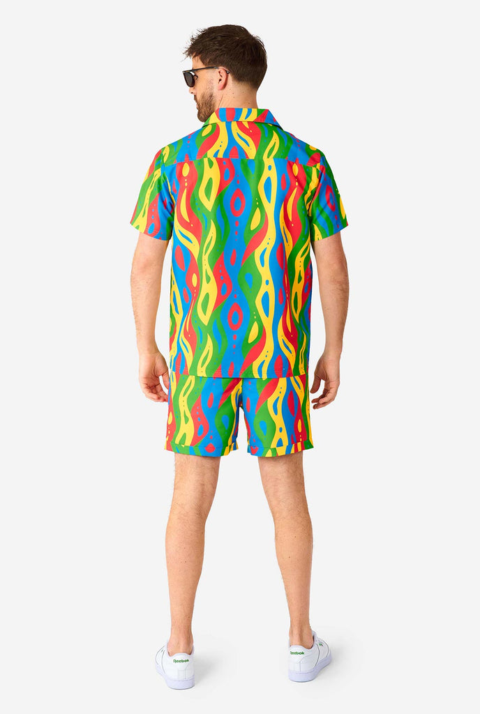 Man draagt ​​een kleurrijke zomerset, bestaande uit shirt en shorts.