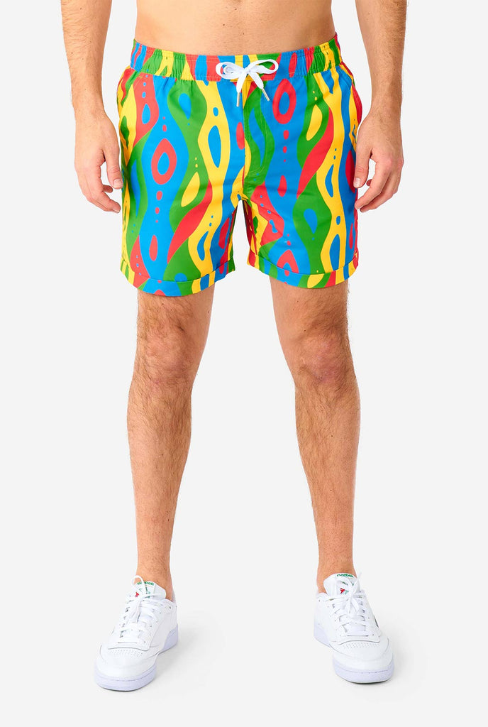 Man draagt ​​een kleurrijke zomerset, bestaande uit shirt en shorts.