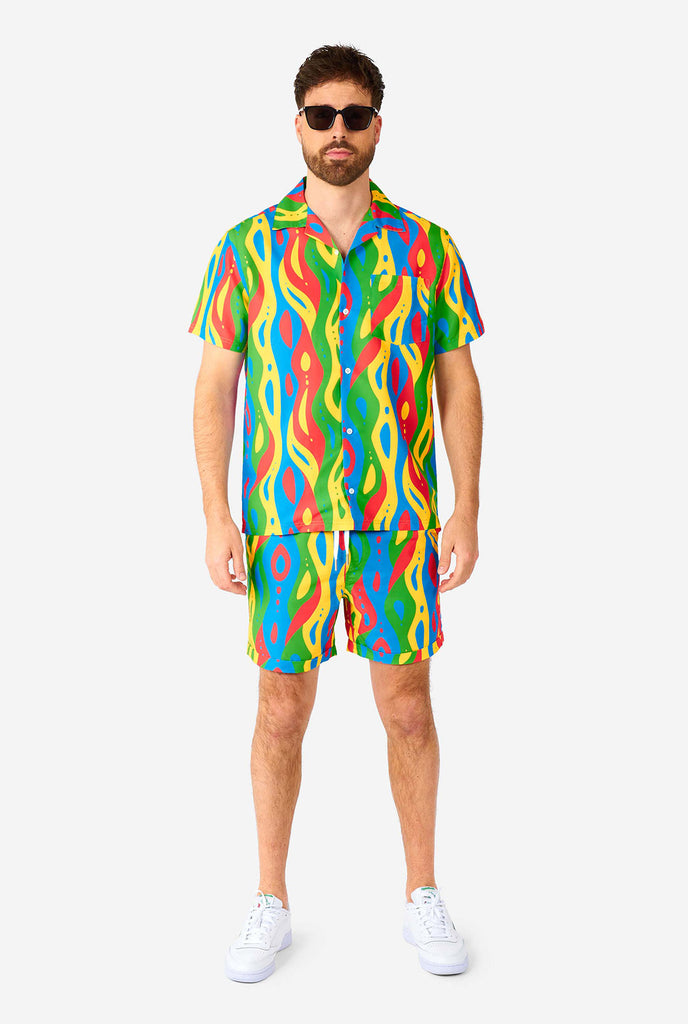 Man draagt ​​een kleurrijke zomerset, bestaande uit shirt en shorts.