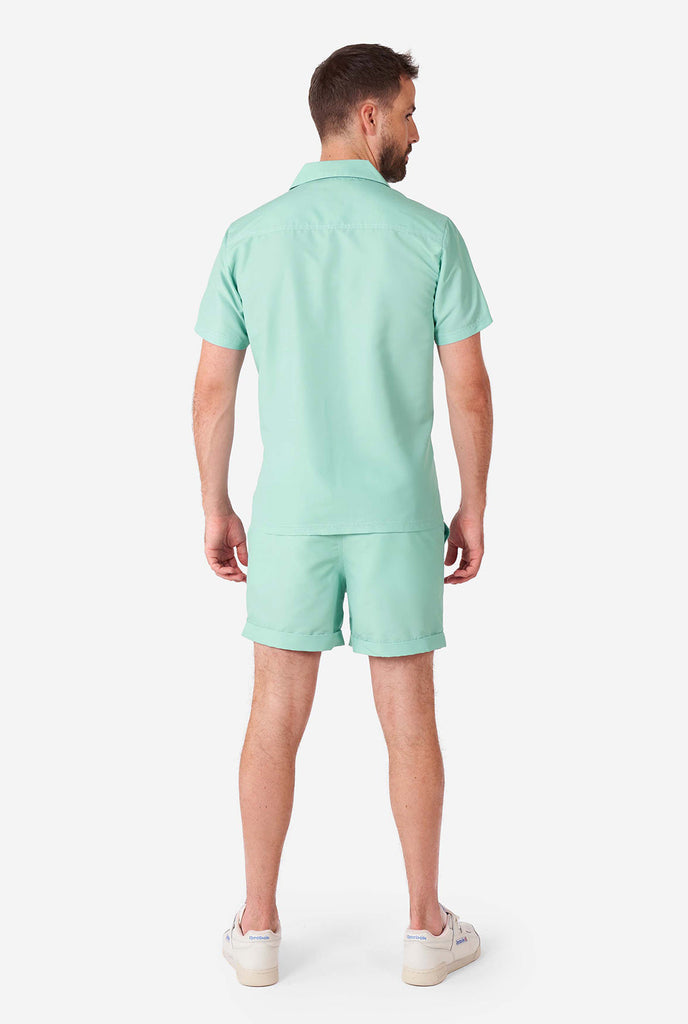 Man draagt ​​een groene zomerset, bestaande uit shirt en shorts met korte mouwen.