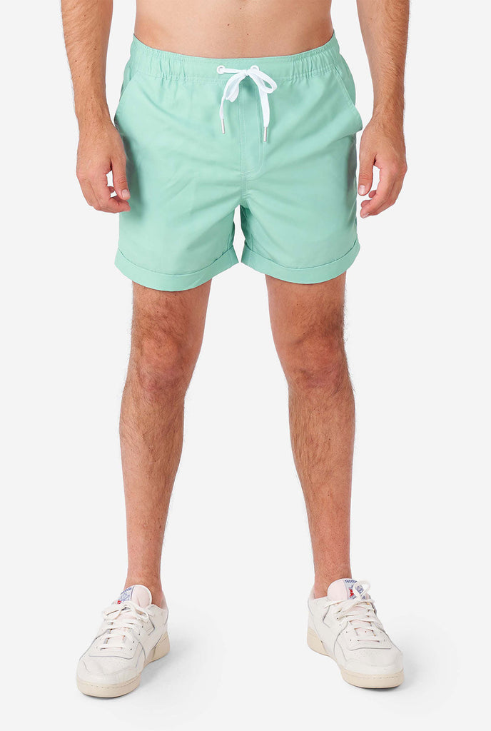 Man draagt ​​een groene zomerset, bestaande uit shirt en shorts met korte mouwen.