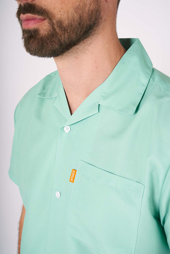 Man draagt ​​een groene zomerset, bestaande uit shirt en shorts met korte mouwen. Detailopname.