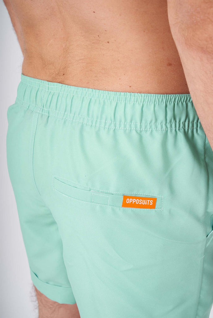 Man draagt ​​een groene zomerset, bestaande uit shirt en shorts met korte mouwen.