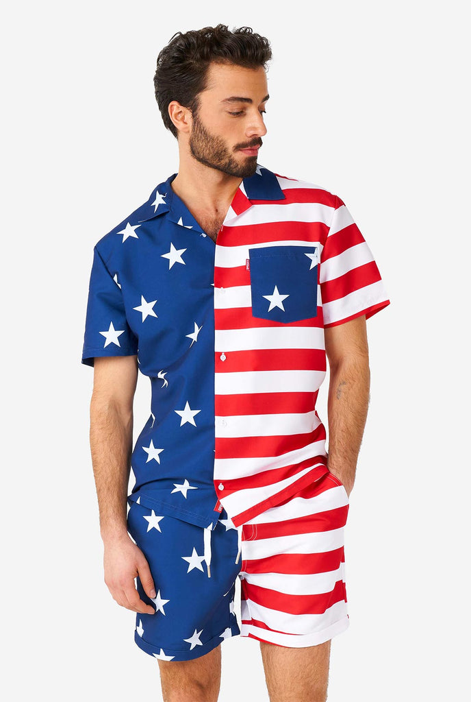 Man draagt ​​zomeroutfit, bestaande uit shirt en shorts, met de Amerikaanse vlaggenprint