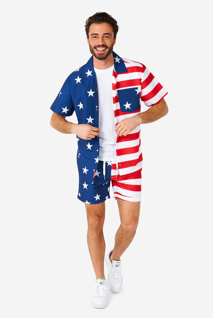 Man draagt ​​zomeroutfit, bestaande uit shirt en shorts, met de Amerikaanse vlaggenprint