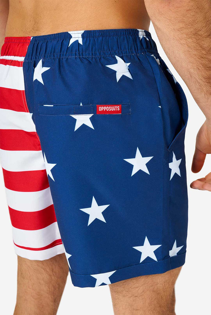 Man draagt ​​zomeroutfit, bestaande uit shirt en shorts, met de Amerikaanse vlaggenprint, shorts close -up