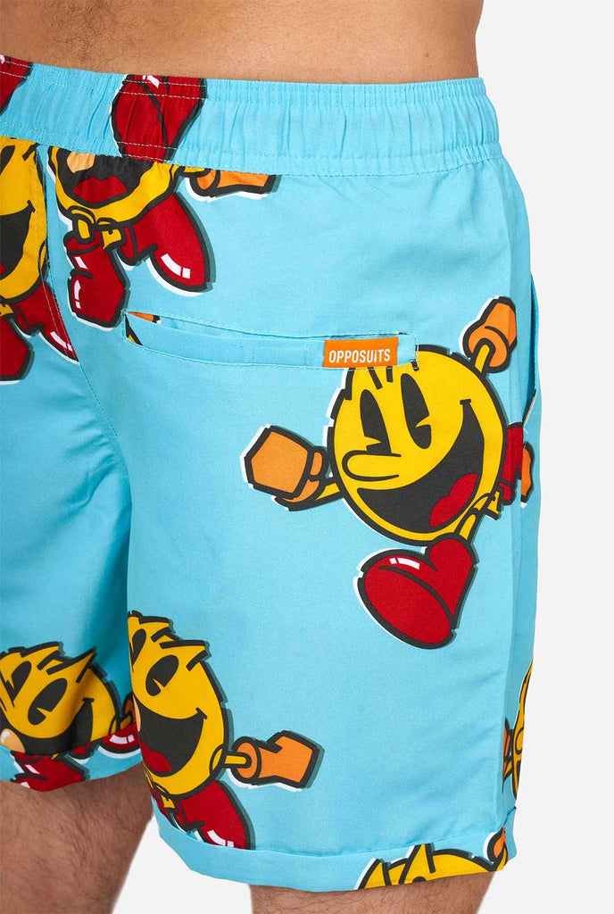 Man draagt ​​blauwe zomers shorts met pac-man print, close-up