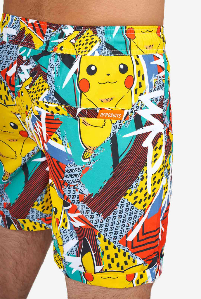 Man draagt ​​een kleurrijke zomerse shorts met Pikachu Pokemon-print, close-up van de achterkant
