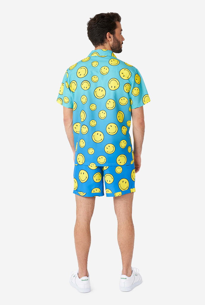 Man draagt ​​een blauwe zomerset, bestaande uit shorts en shirt, met smiley print, bekijk vanaf de achterkant