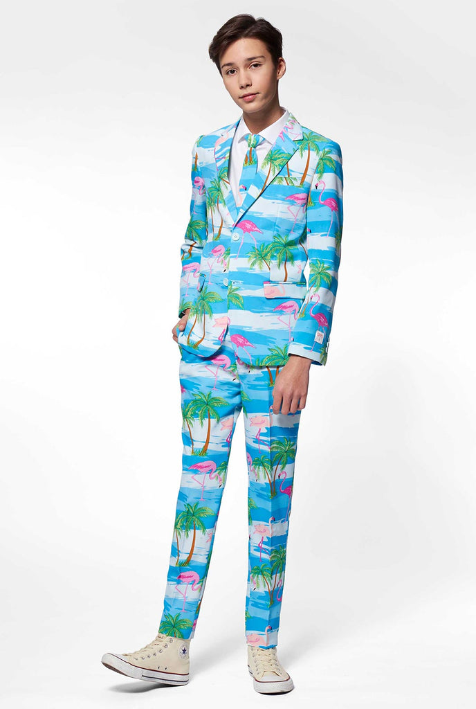 Tiener draagt ​​een lichtblauw pak met flamingo palmboomprint