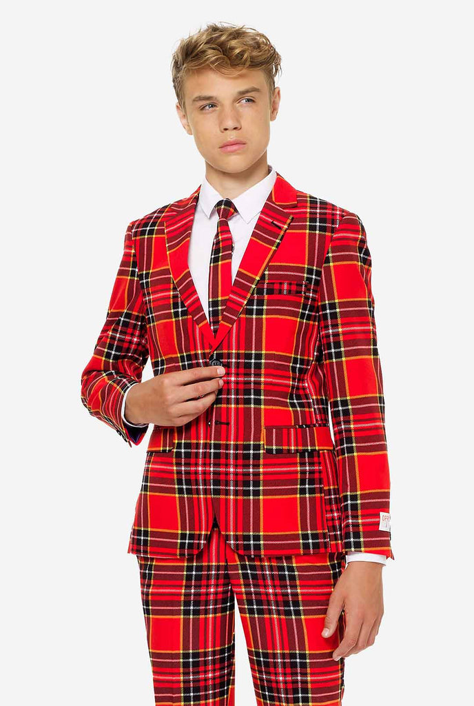 Tiener met een rood tartan kerstpak