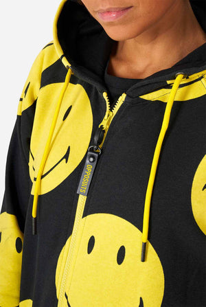 Vrouw die zwarte onesie draagt ​​met gele smileyprint, borst dichtbij