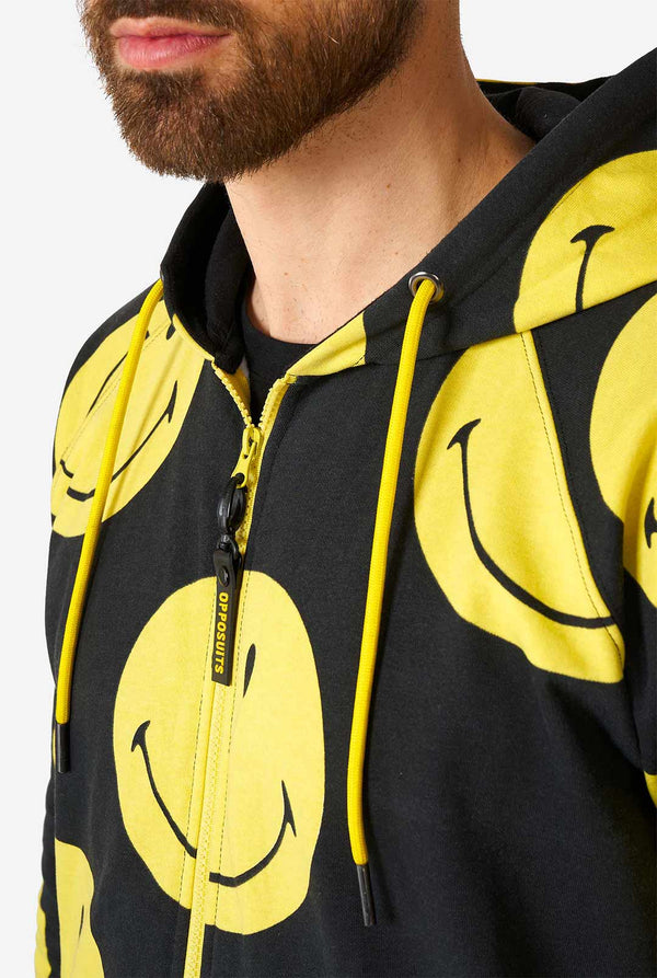 Man draagt ​​zwarte onesie met gele smileyprint, borst dichtbij