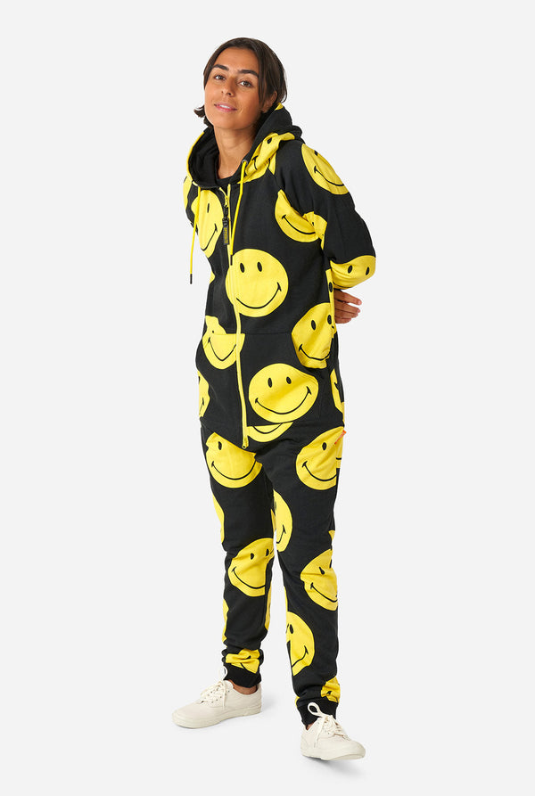 Vrouw draagt ​​zwarte onesie met gele smileyprint