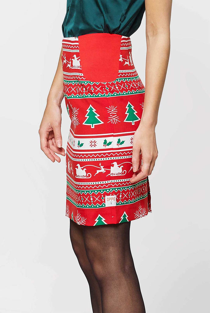 Vrouw met een rood kerstpak met kerstpictogrammen, uitzicht op het rok