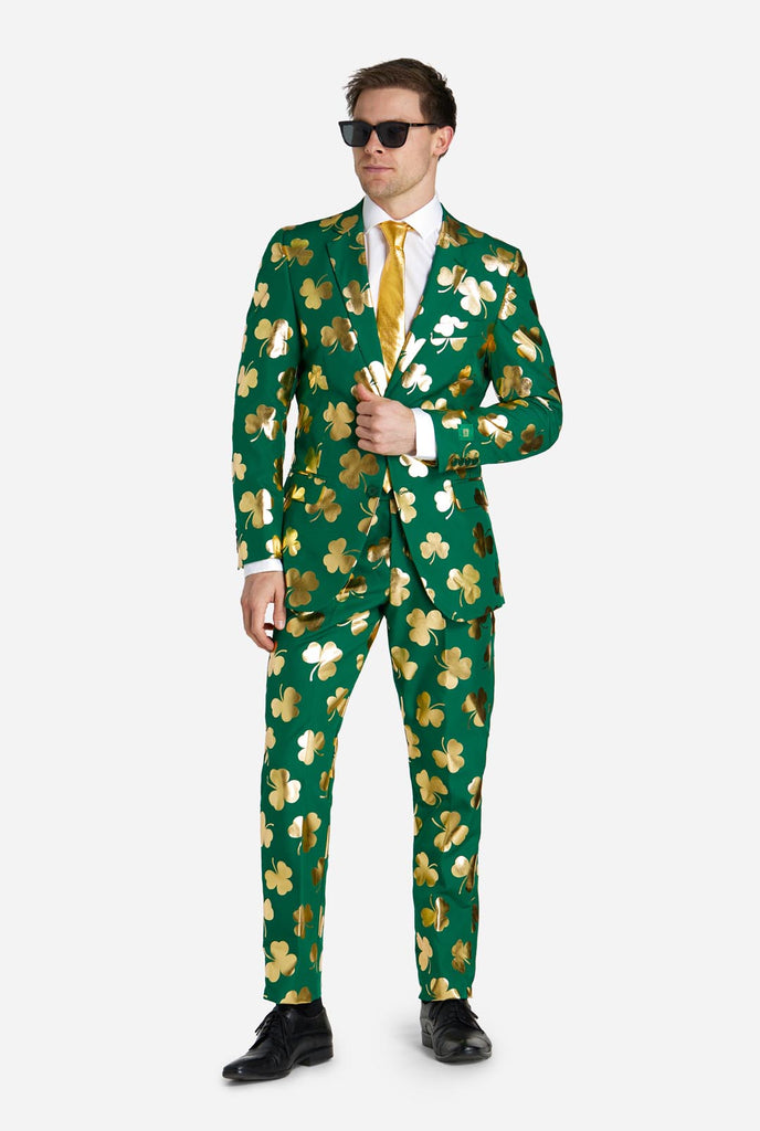 Man wearing green St Patrick's Day suit with golden clovers.